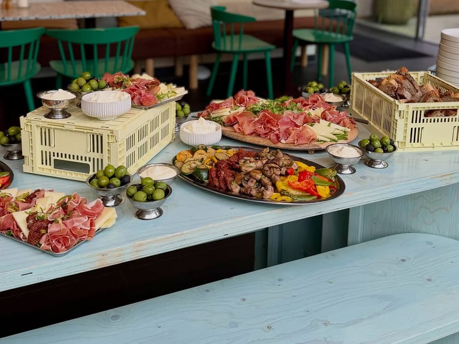 Buffet mit Antipasti, Aufschnitt und Brot in Stapelkisten